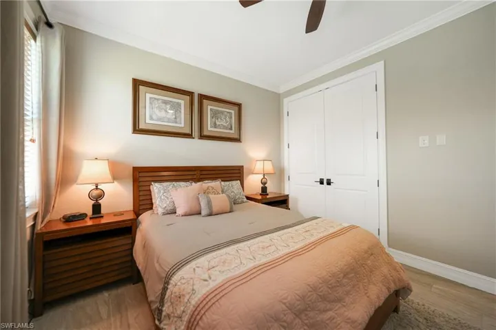 Bedroom featuring crown molding, light hardwood / wood-style floors, a closet, and ceiling fan