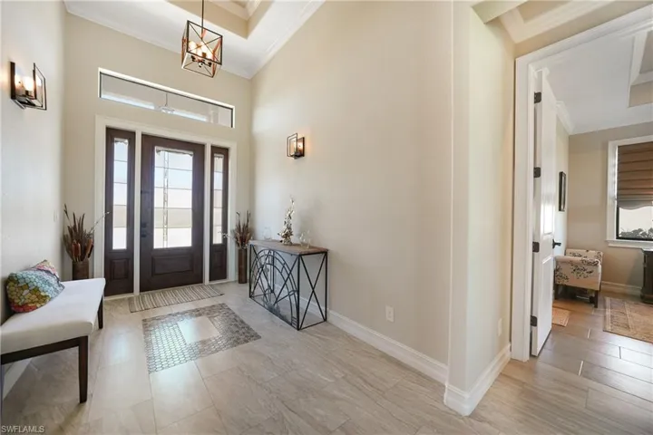 Foyer entrance featuring ornamental molding and a chandelier