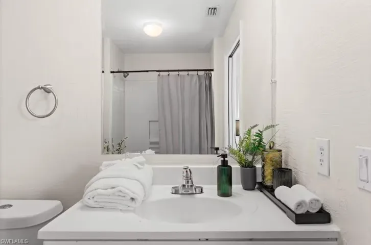 Bathroom featuring a shower with curtain and vanity