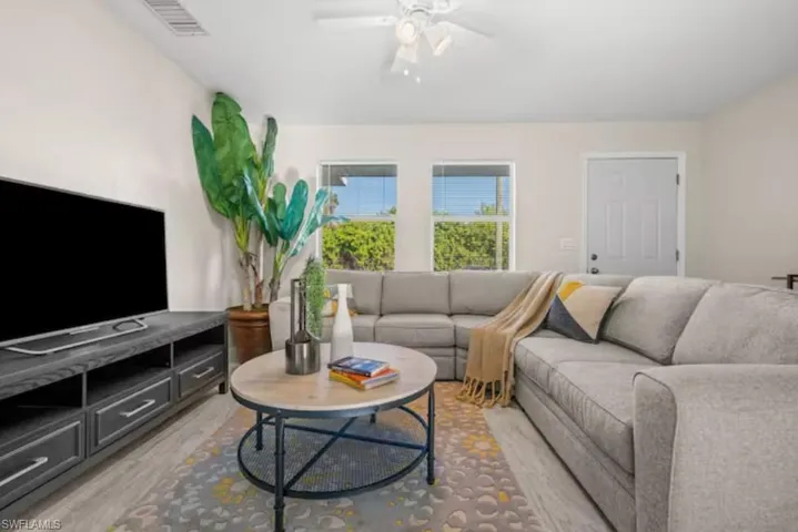 Living area with ceiling fan and light wood-type flooring