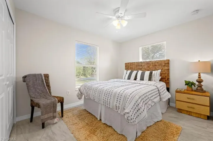 Bedroom with a closet, ceiling fan, and multiple windows