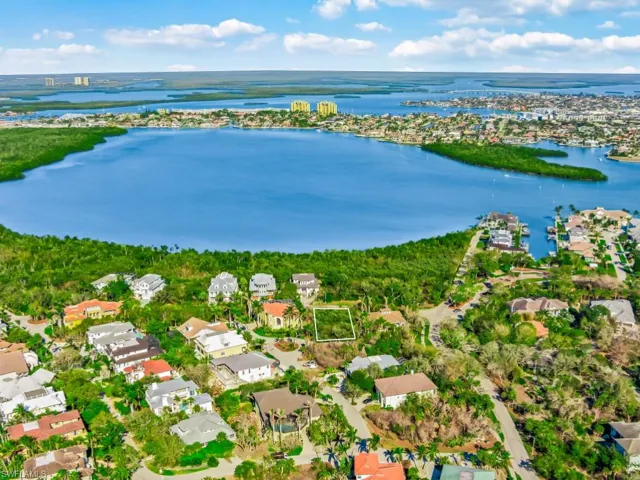 Aerial perspective of suburban area featuring a nearby body of water