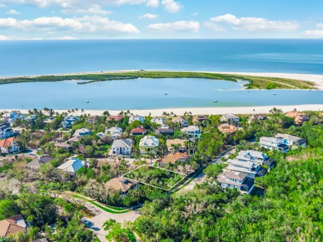 Aerial view of residential area with a nearby body of water and property boundaries highlighted