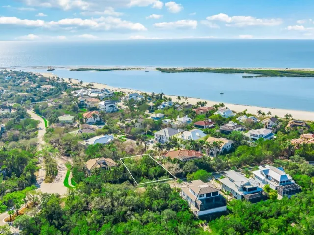 Aerial perspective of suburban area with property boundaries highlighted and a large body of water