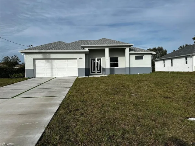 View of front facade with a garage and a front lawn