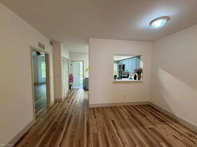 Unfurnished room with wood finished floors and baseboards