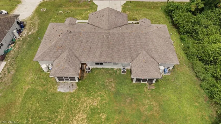Expansive property featuring a large, multi-gabled roofline with asphalt shingles