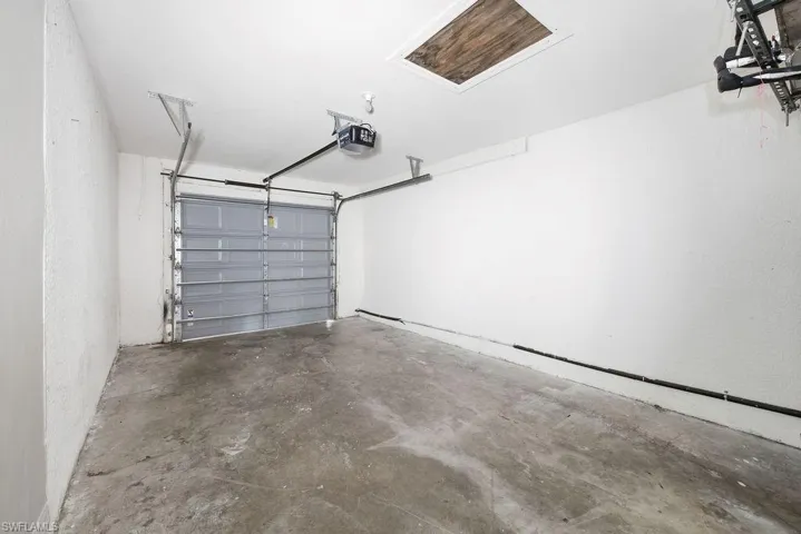 Single-car garage with a gray sectional overhead door and automatic opener