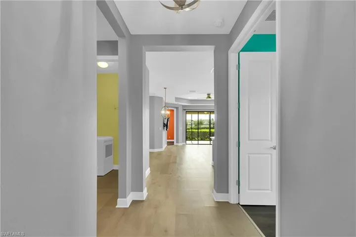 Hallway with light wood-style floors and baseboards
