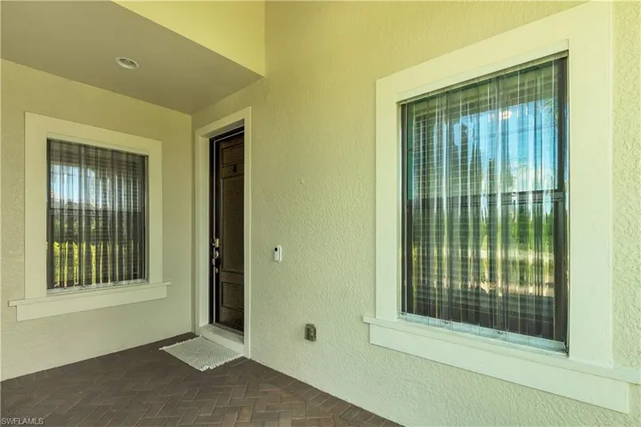 Doorway to property featuring stucco siding and a patio