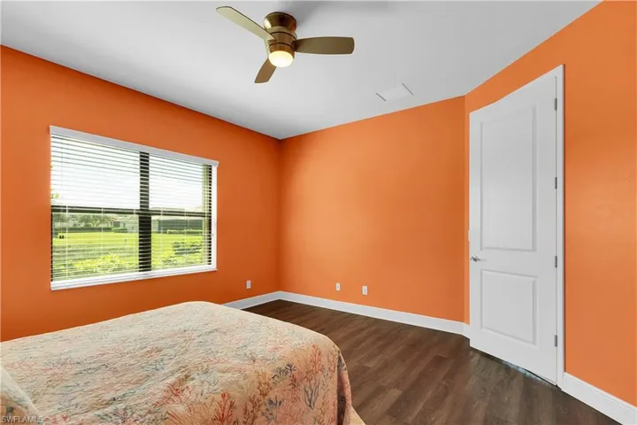 Bedroom with dark wood-type flooring and a ceiling fan