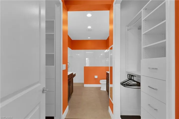Full bath with vanity, a walk in shower, recessed lighting, and light tile patterned floors