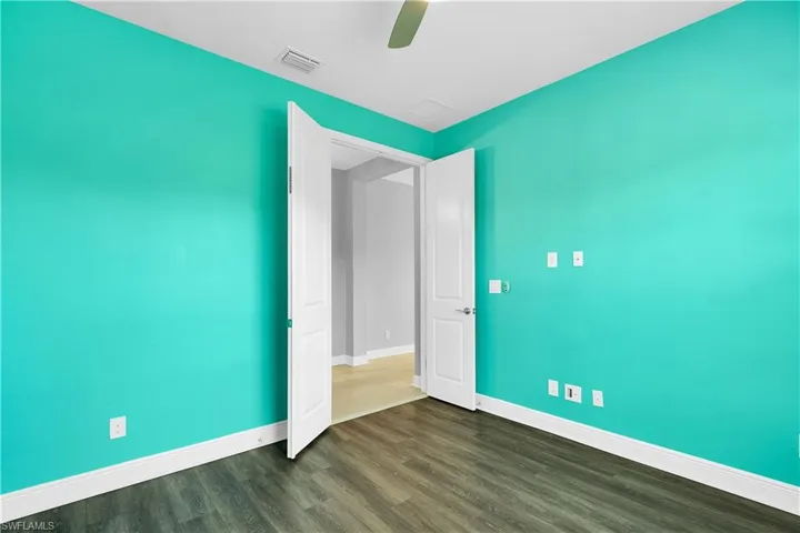 Unfurnished bedroom featuring dark wood finished floors and a ceiling fan