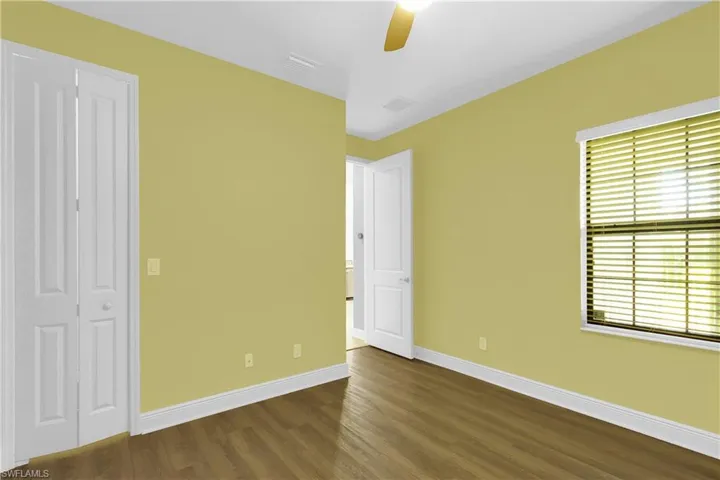 Unfurnished bedroom with dark wood-type flooring and a ceiling fan