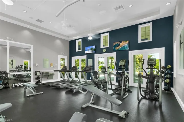 Gym with recessed lighting, a high ceiling, and a ceiling fan
