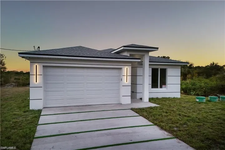 View of front of home with a yard and a garage