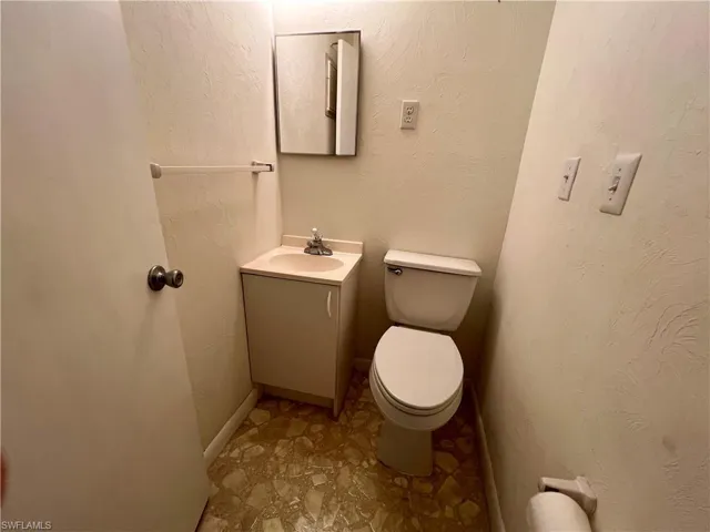 Bathroom featuring tile floors, vanity, and toilet