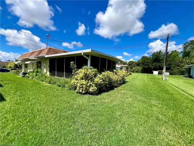 View of side of home with a yard and central air condition unit