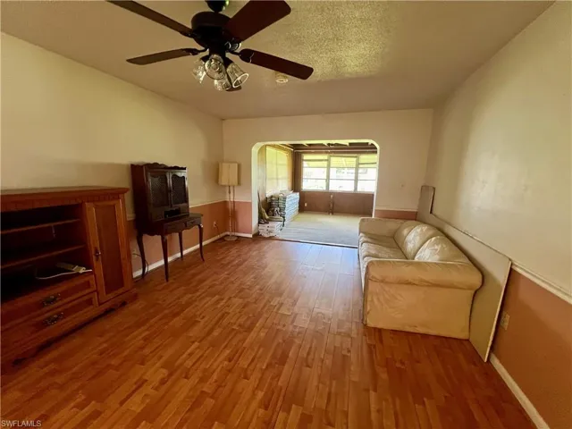 Sitting room with laminate / wood-style floors and ceiling fan