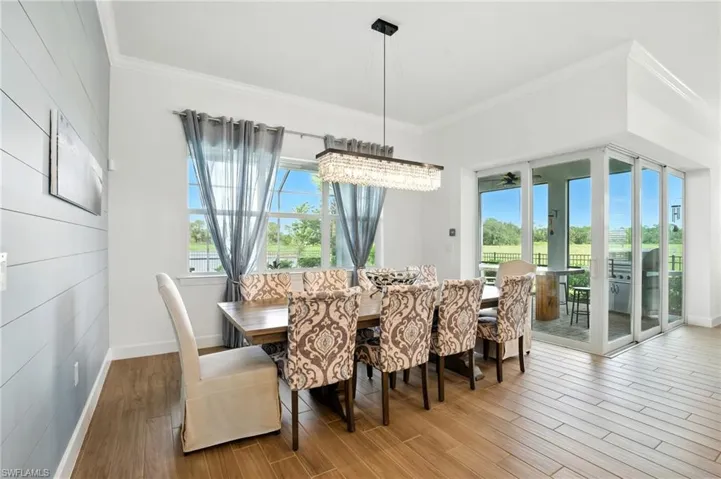 Dining area featuring wood finished floors, ornamental molding, a chandelier.
