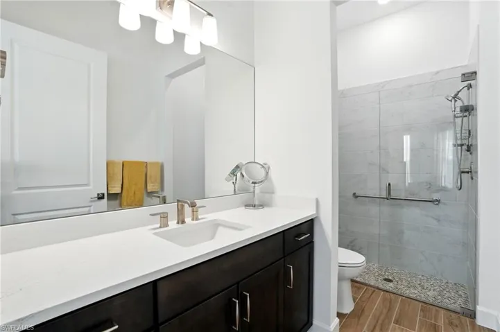 Bathroom featuring vanity, wood look tiled floors, and a shower stall