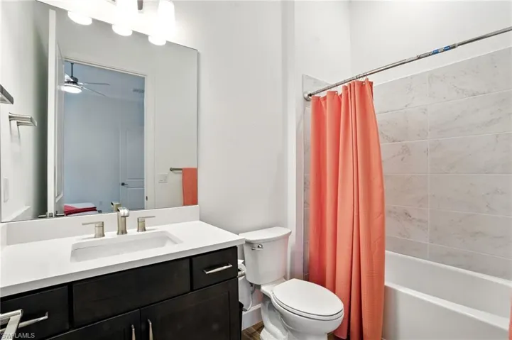 Full bath featuring shower / bath combo, vanity, and ceiling fan