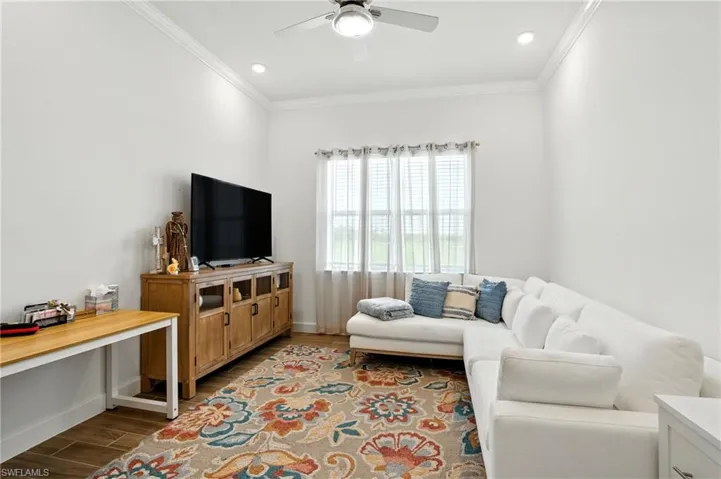Den featuring wood look finished floors, ornamental molding, recessed lighting, and a ceiling fan