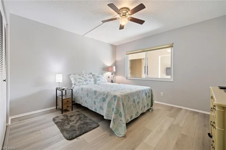 Room featuring light wood-finish flooring, a ceiling fan with integrated lighting, and a large window