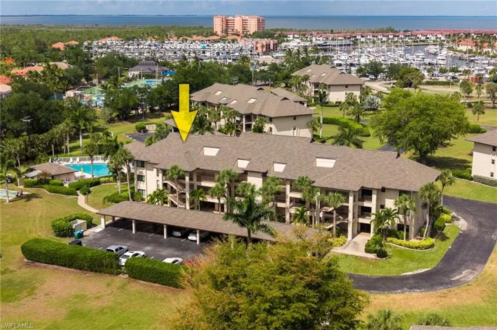 Multi-story condominium building featuring a shingle roof and multiple balconies