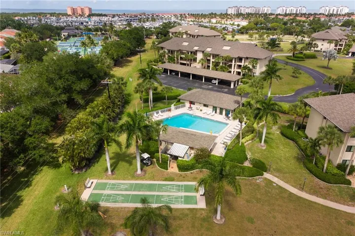 Community amenities featuring a swimming pool, shuffleboard courts, and mature landscaping