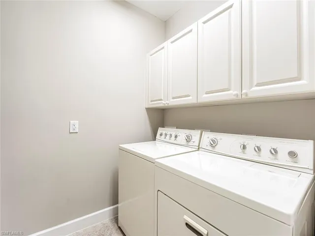 Laundry area featuring washing machine and clothes dryer and cabinet space