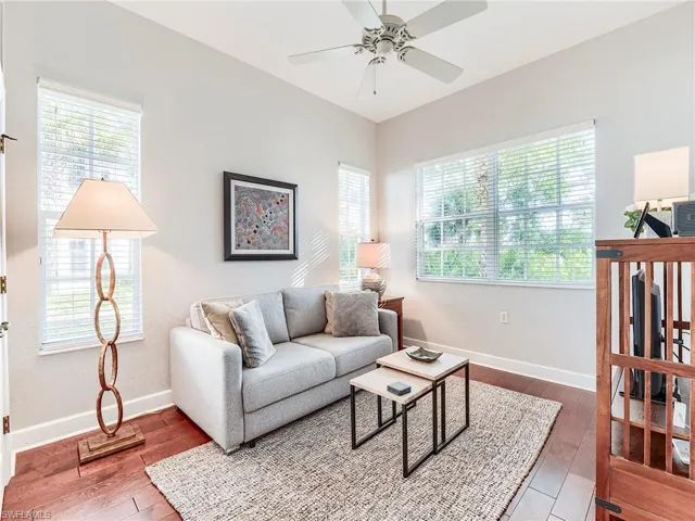 Living room with hardwood floors, plenty of natural light, and a ceiling fan
