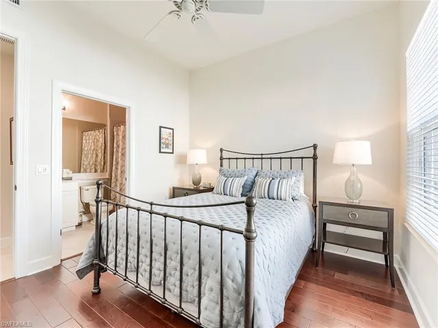 Bedroom featuring a ceiling fan, hardwood wood floors, and ensuite bathroom
