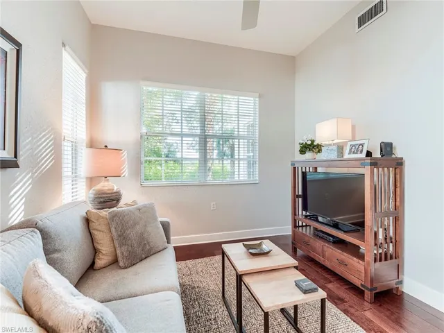 Living room with dark wood finished floors and a ceiling fan