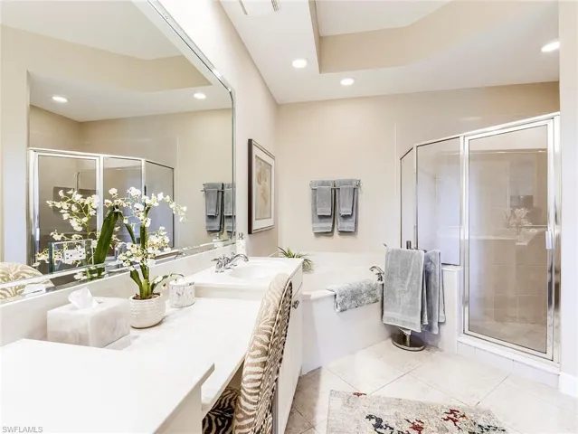 Bathroom with a shower, double vanity, a garden tub, recessed lighting, and light tile patterned floors