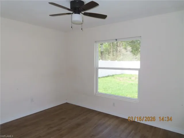 Spare room featuring dark wood-style floors and a ceiling fan