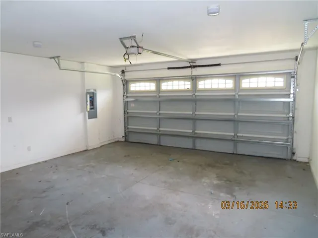 Garage featuring electric panel and a garage door opener