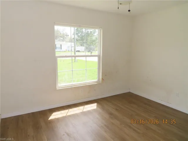 Empty room featuring baseboards and wood finished floors