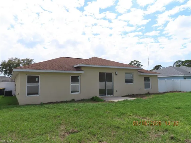 Rear view of property with a patio, stucco siding, and a shingled roof