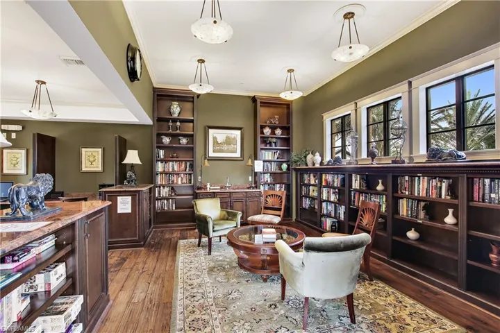 Sitting room with dark hardwood / wood-style floors and crown molding