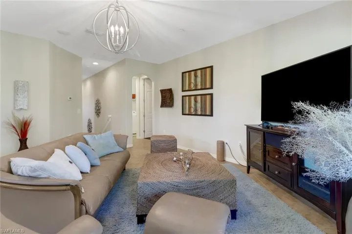Living room with light tile patterned floors and an inviting chandelier