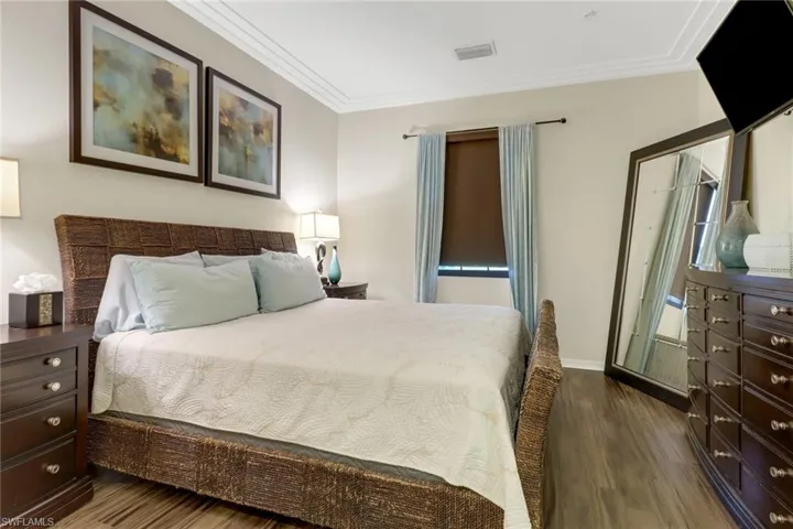 Bedroom featuring dark hardwood / wood-style floors and crown molding
