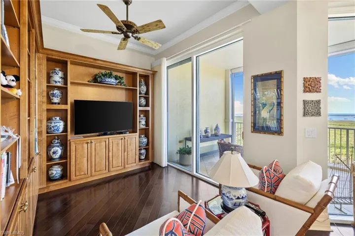 Primary suite room with crown molding, a ceiling fan, and dark wood finished floors