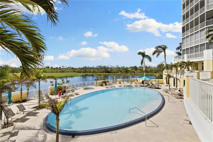 Jasmine Bay Community pool with a patio area, a community hot tub, and a water view