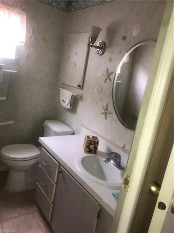 Bathroom with tile patterned floors, toilet, and vanity