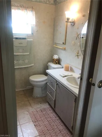Bathroom featuring vanity, tile patterned floors, and toilet