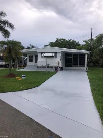 View of front facade with a carport and a front lawn