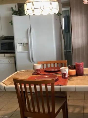 Dining space with wood walls and tile patterned floors