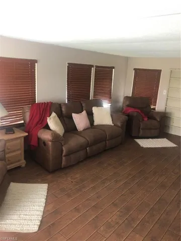 Living room with dark wood-type flooring