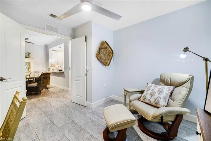 Living area with ceiling fan and crown molding